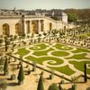 The Orangery at the Palace of Versailles, with swirling manicured lawns and ornamental trees