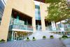 Exterior view of the Mint Museum in Charlotte featuring a sculptural sandstone-colored building with large glass windows.