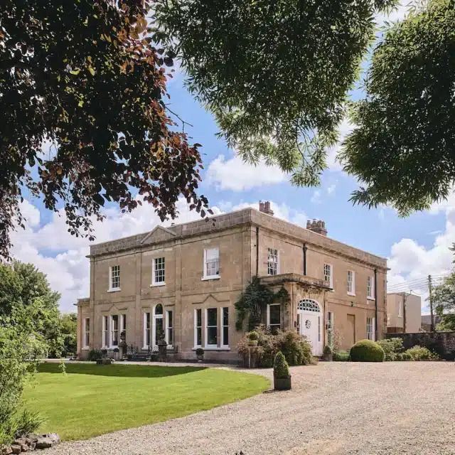 A stately two-story manse surrounded by a well-kept lawn