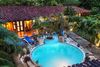 Overview of a circular swimming pool surrounded by hotel lodging.