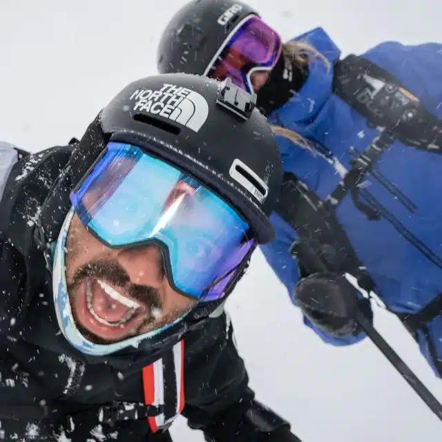 Skier and accessibility activist Vasu Sojitra smiles alongside fellow skier Sophia Rouches in the snow