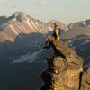 A person sits on top of a steep rock formation in the Rocky Mountain National Park