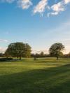 The lush grounds of Malahide Castle in County Dublin, Ireland with two trees against a blue, slightly cloudy sky