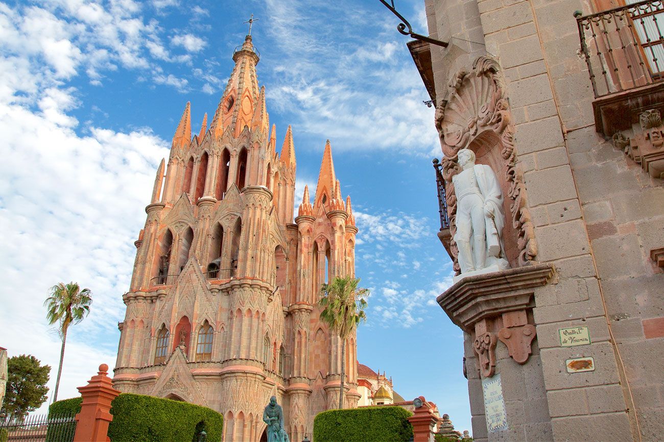 Pink stone building with elaborate roof turrets. 
