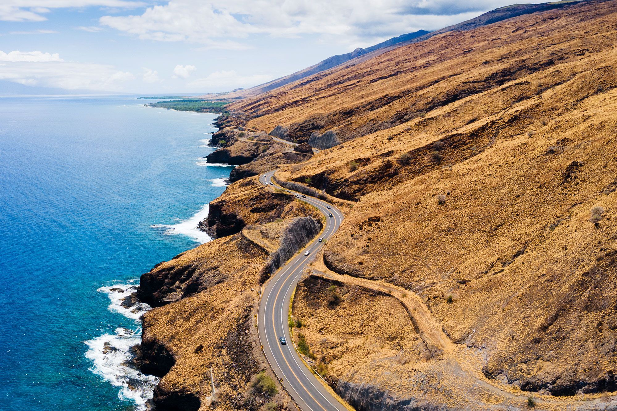 Aerial view of a road twisting and turning along a coastline.