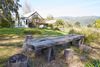 Rustic barn farmhouse in nature located in Bolinas, California with an old wooden table and stumps for seating in the foreground