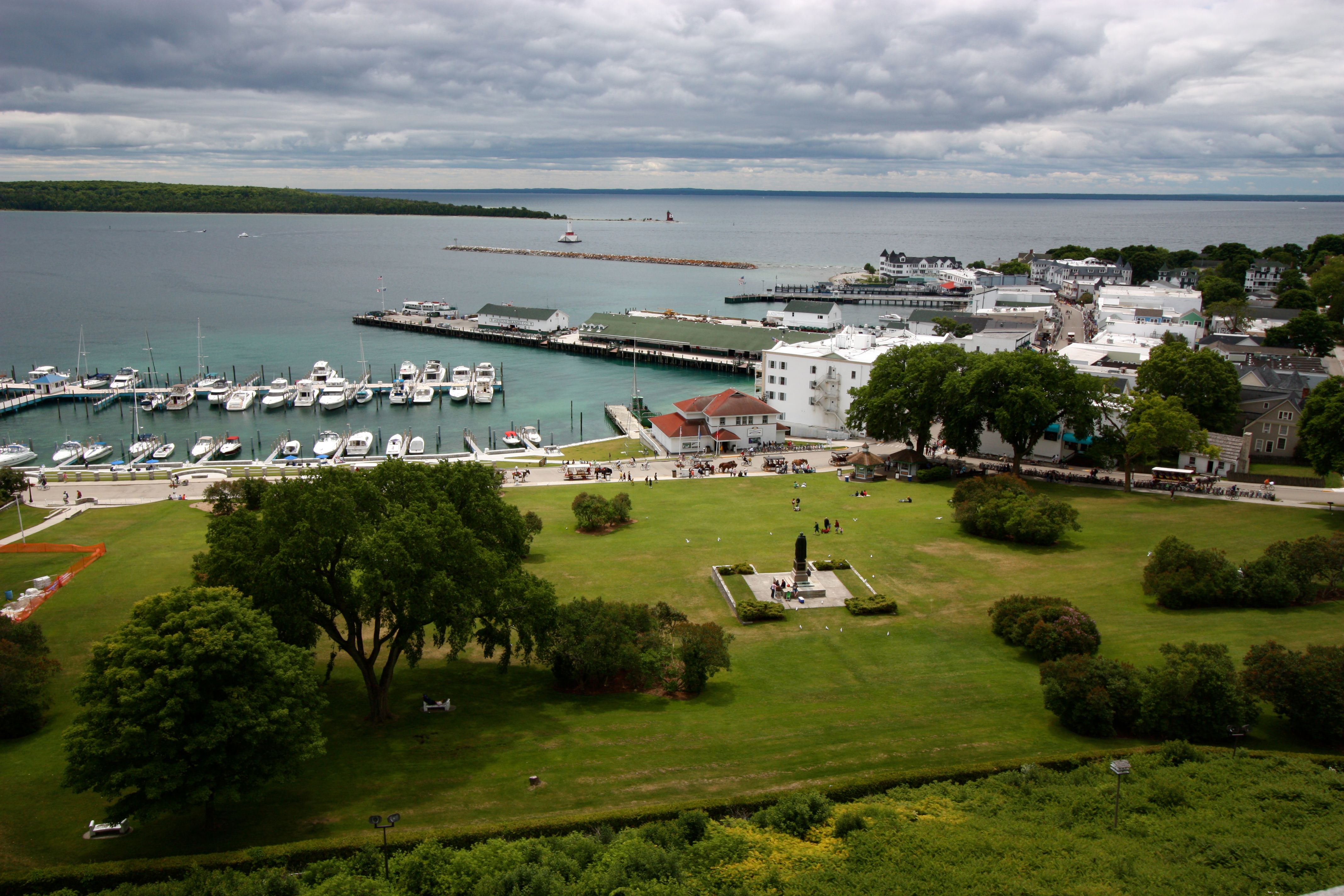 Looking down from Fort Mackinac on Mackinac Island with a view of rolling grassy hill to the port at the Straits of Mackinac between Lake Michigan and Lake Huron. 