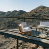 Sun covers the raised terrace and white-cushioned outdoor furniture at a Vrbo holiday rental out in the desert in Terlingua, Texas