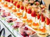 Gourmet bite-sized appetizers lined up with caviar, prosciutto and strawberries.