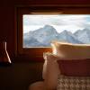 The French Alps are seen through the window of a bedroom at Grandes Rousses Hotel & Spa in Huez, France
