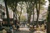 People walk around the tree-lined, cobbled streets of Quincy Market in Boston, Massachusetts