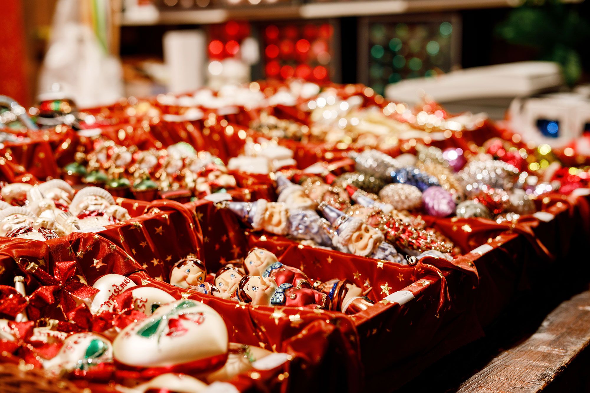 Different ornaments sitting in red lined boxes on display for sale.