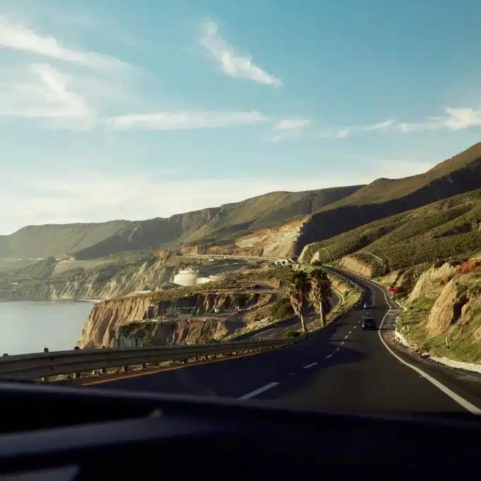 A road running between coastline and hillside in Tijuana, Mexico