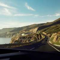 A road running between coastline and hillside in Tijuana, Mexico
