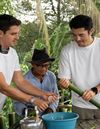 Antoni Porowski and Henry Golding learn how to fill bamboo with rice at Pematoh Longhouse. Photo: National Geographic/Rebecca Eishow