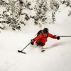 Pro skier and accessibility activist Vasu Sojitra skis down a mountain in ski gear