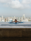A person looks out over panama city from an infinity pool