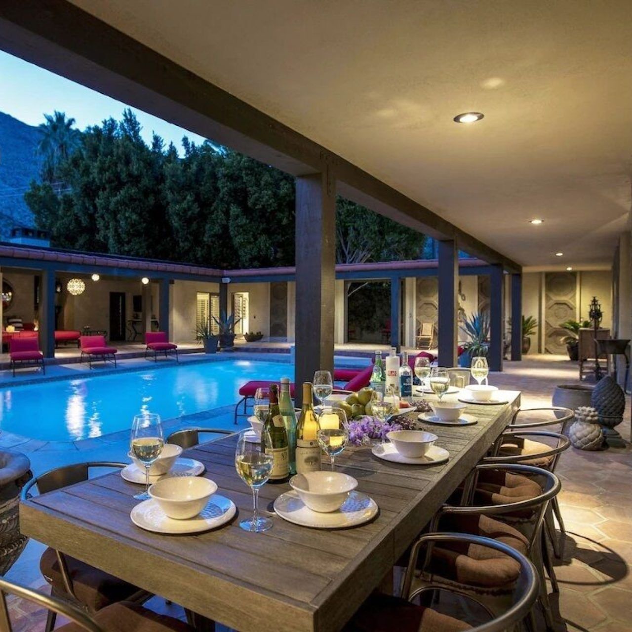 A table set for dinner beside a pool at a Vrbo once lived in by Sonny and Cher