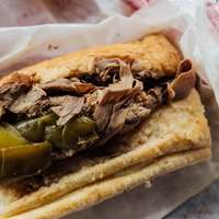 A close-up of a beef sandwich with pickles, a classic Chicagoan specialty
