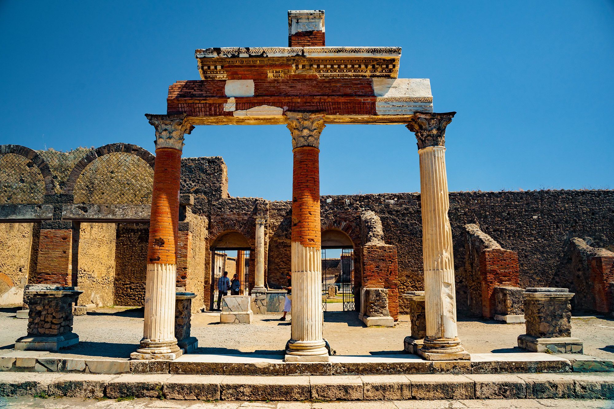 Old arch ruins stand tall in Pompeii, Italy.