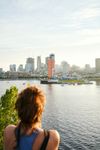 A woman with red hair looks out over the Saint Lawrence River to the city skyline in Montreal, Québec