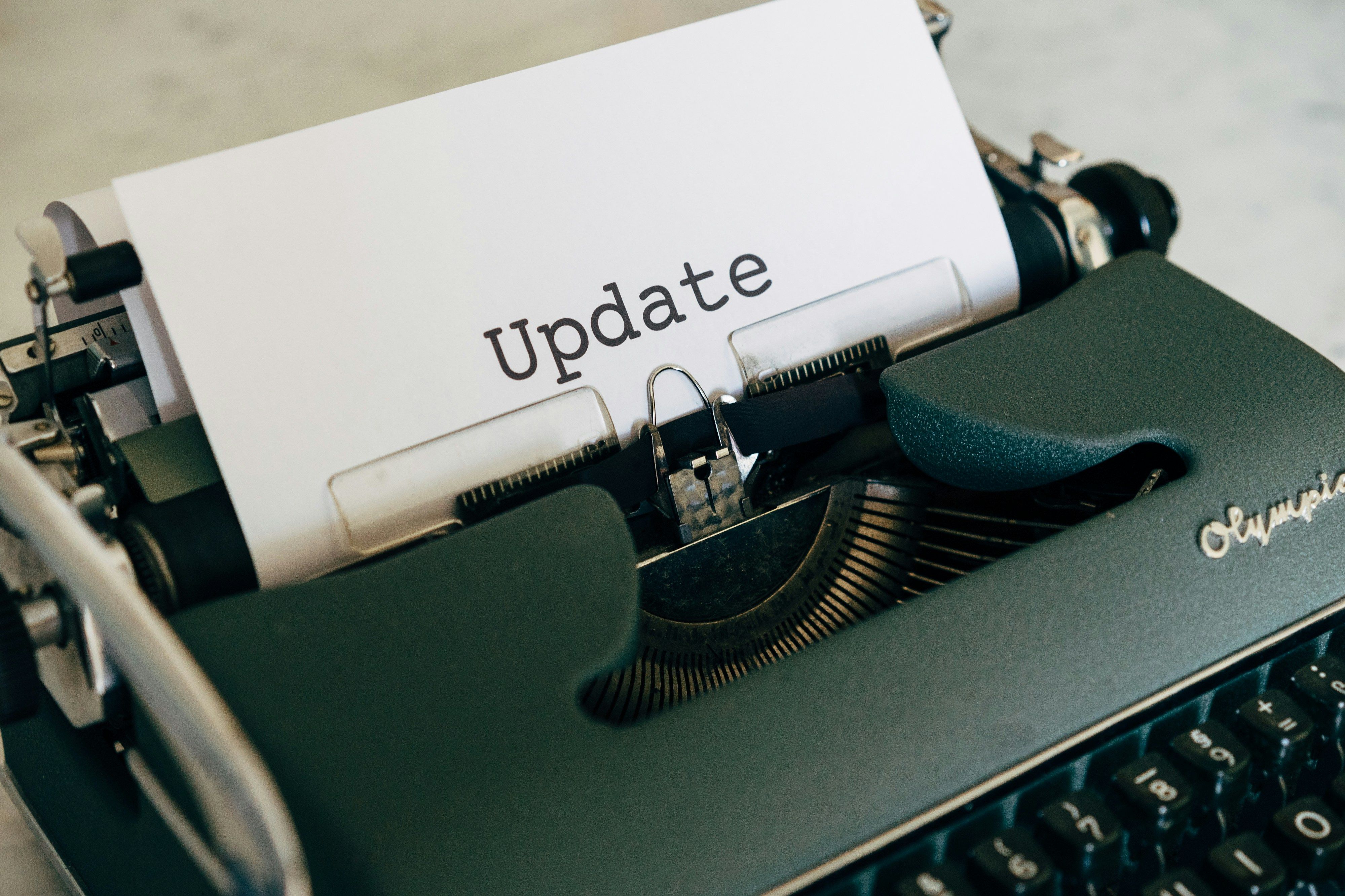 A vintage typewriter with the word "Update" typed on a sheet of paper.