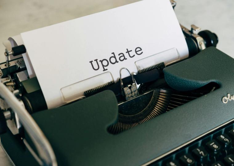 A vintage typewriter with the word "Update" typed on a sheet of paper.