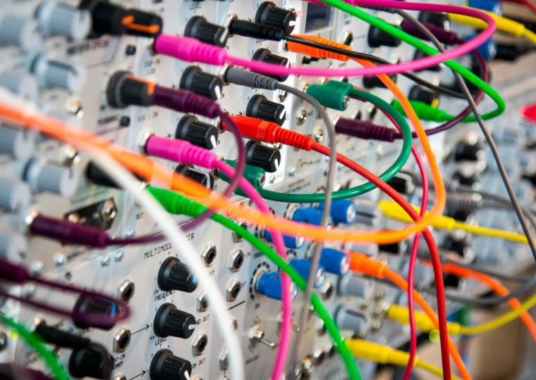 Modular synthesizer with numerous colorful patch cables.