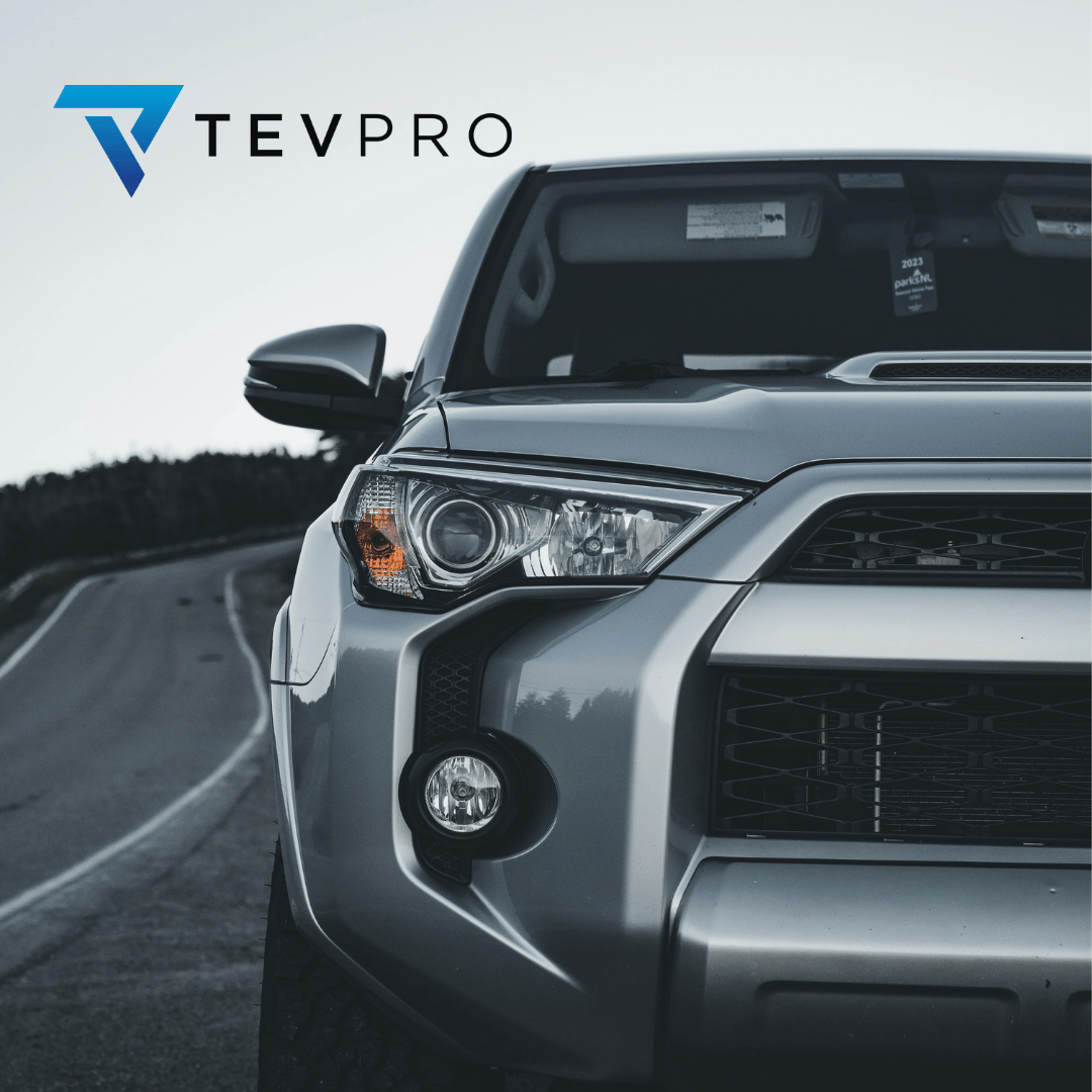 TEVPRO logo and the front of a silver SUV on a winding road.