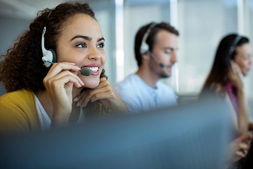 Smiling customer service agent in an office talking into headset