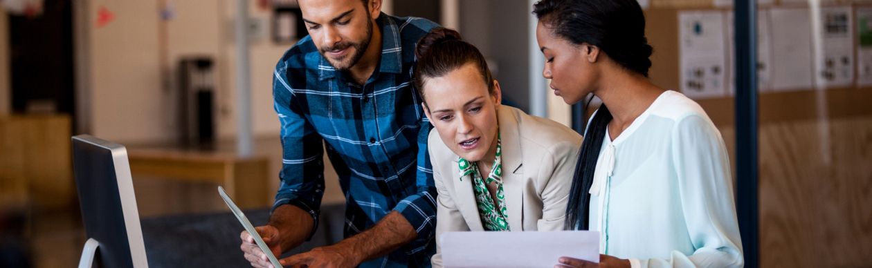 A group of CX leaders huddling over a computer to compare Salesforce service cloud with Gladly