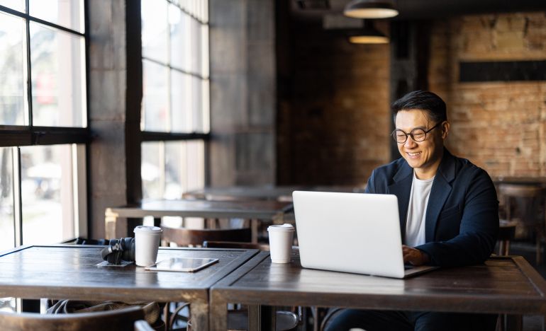 Bespectacled man working on a laptop