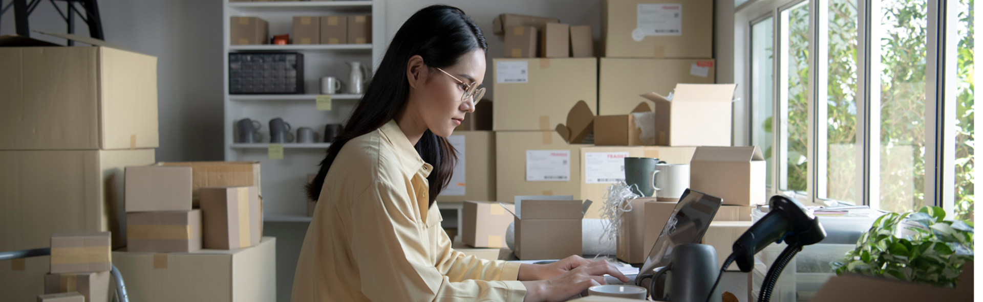 Woman on a laptop in a room full of boxes