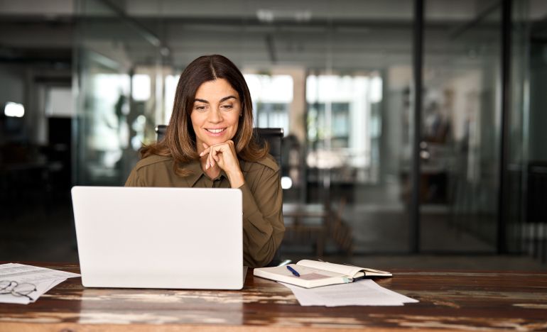 Businesswoman smiling ponderously at her laptop