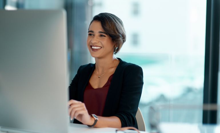 A CX leader working at her computer to improve her leadership skills and by extension, customer service