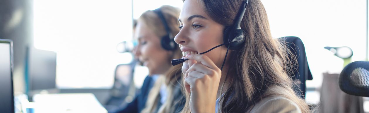 An agent working at her computer and happier because between Ticket-based vs customer-based, the platform she's using uses customer-based