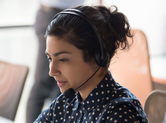 Customer service agent with headset on computer