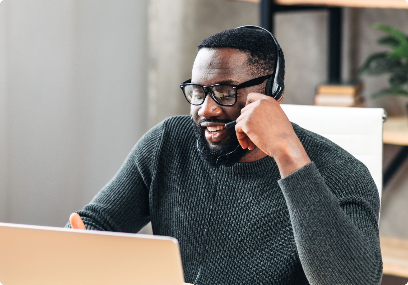 Man talking on a headset while working on a computer