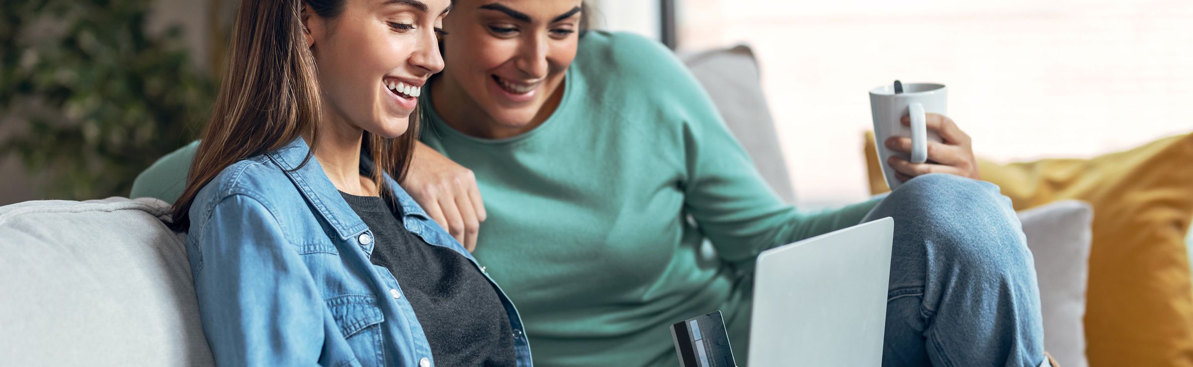Two women shopping on a laptop