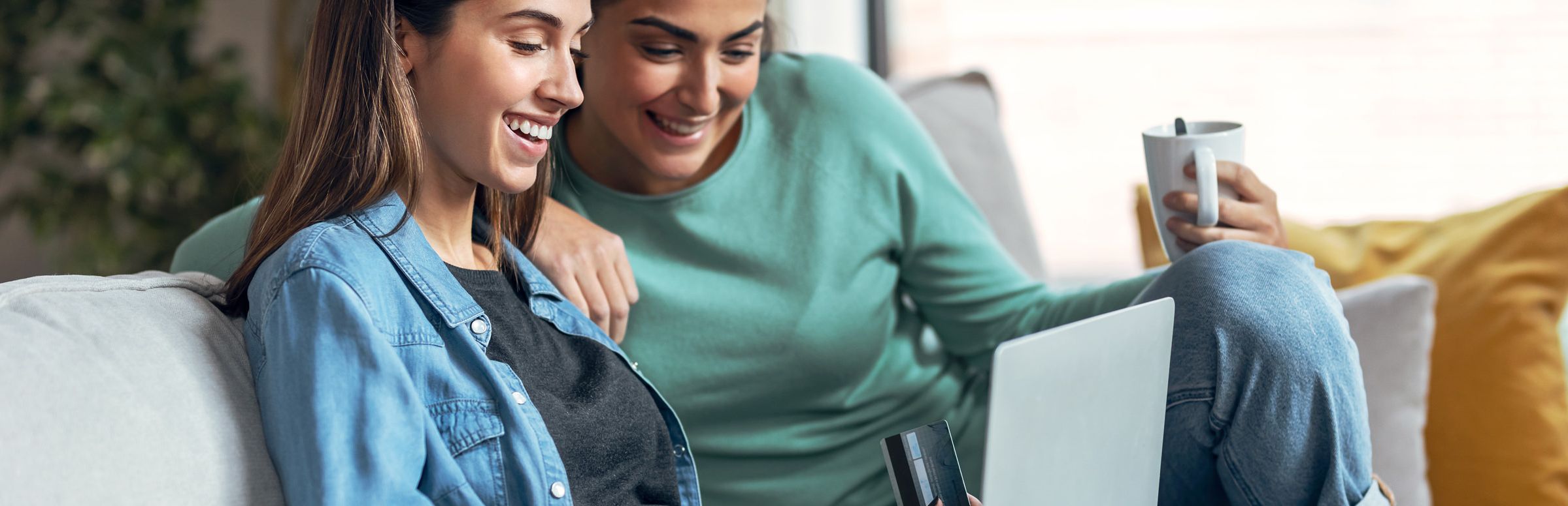 Two women shopping on a laptop