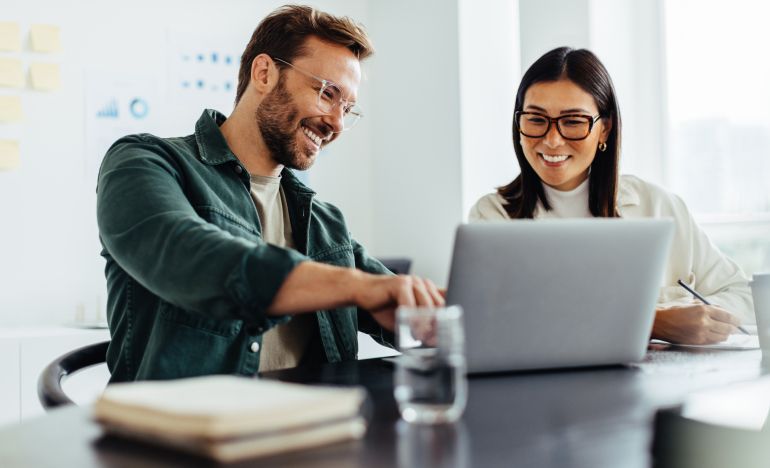 CX experts discussing AI for Better Customer Interactions on their laptop
