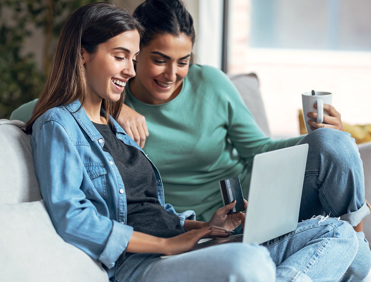 Two women shopping on a laptop