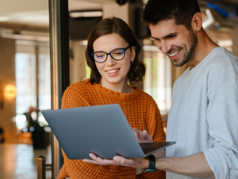 Two coworkers, man and woman, working on laptop 