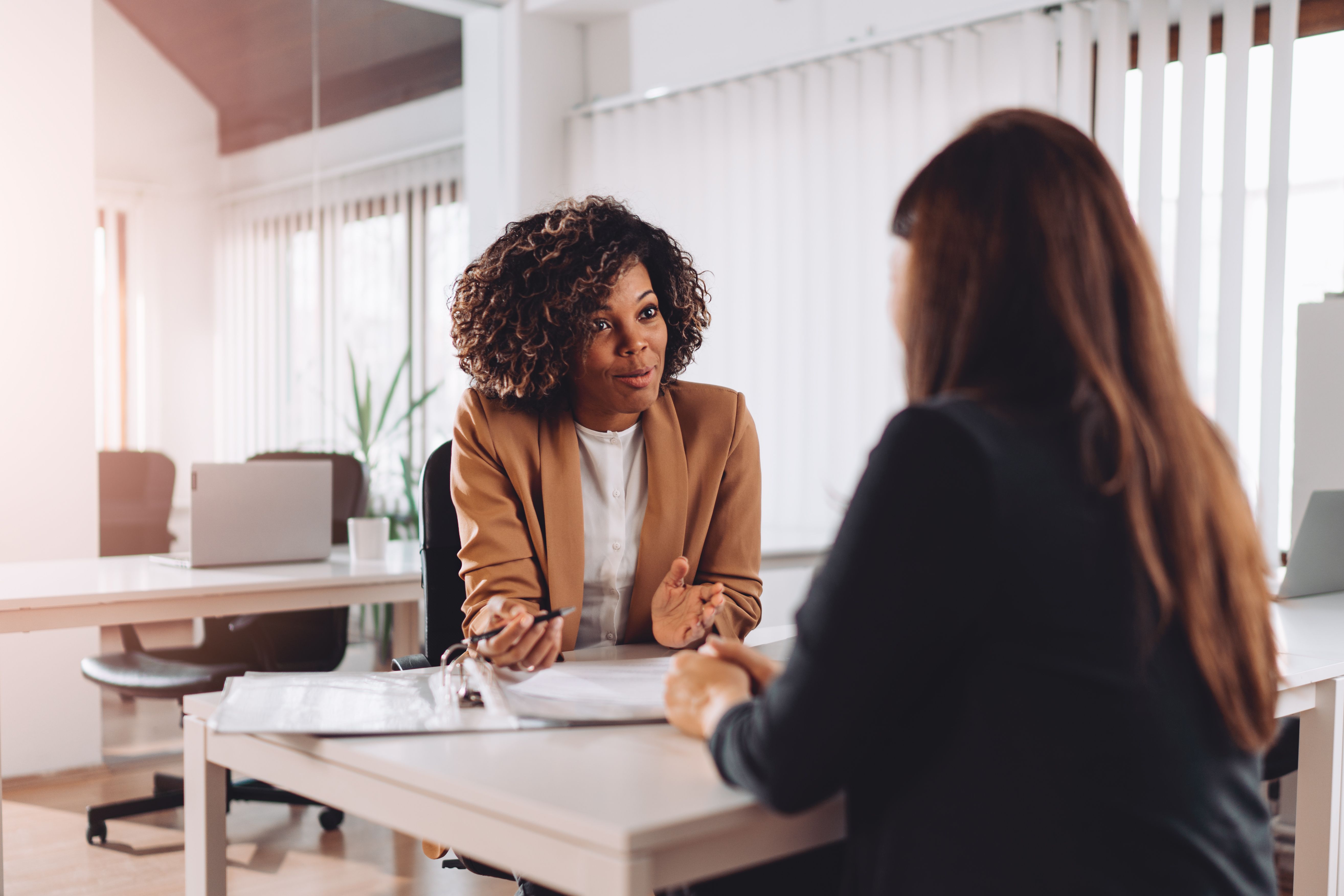 Two women sitting across the table in an interview