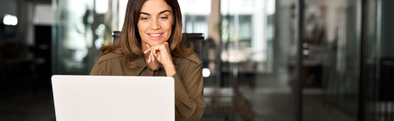 Businesswoman smiling ponderously at her laptop