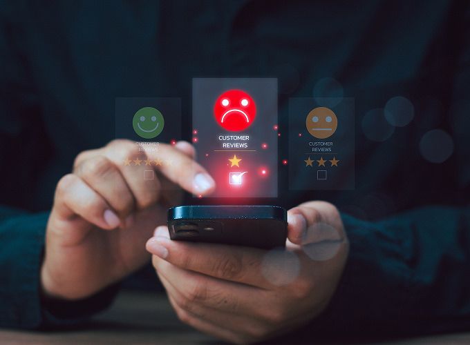 Hands holding phone leaving poor customer review