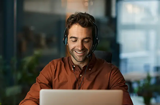 Man wearing headset working at laptop