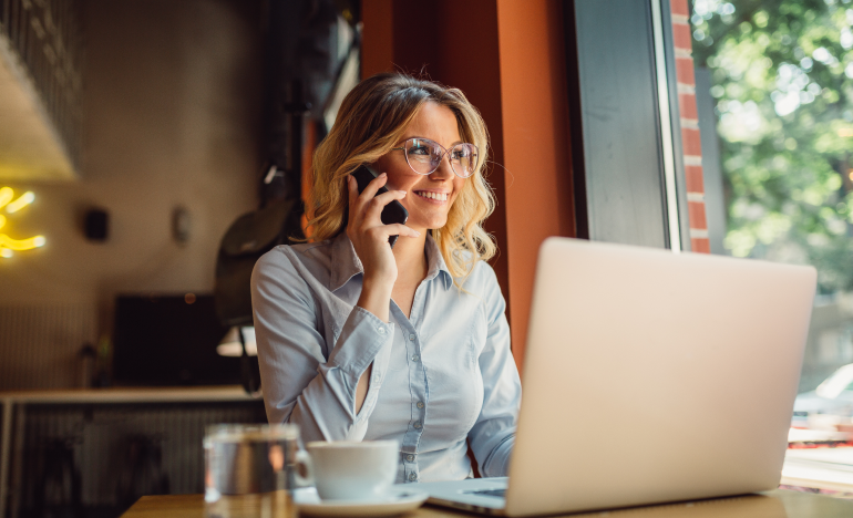 woman having a call while using laptop