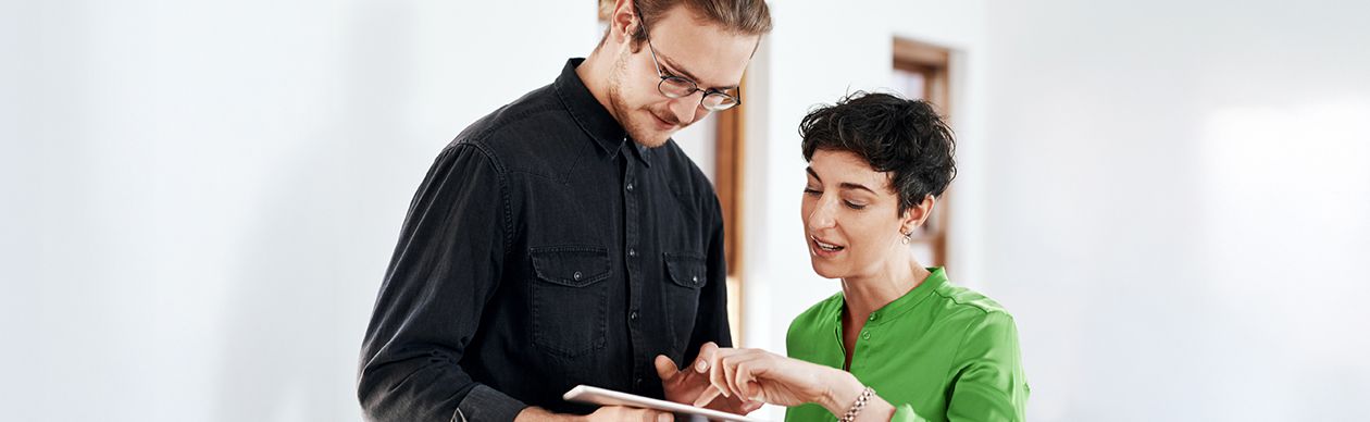 Two people talking over a tablet