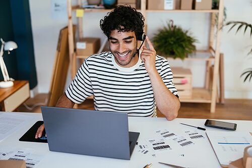 Man wearing headset smiling on laptop